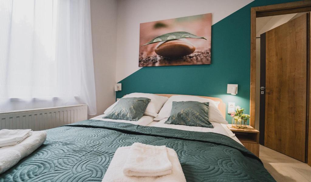 ein Schlafzimmer mit einem Bett und einem Wandgemälde in der Unterkunft Szent Miklós Apartman -Keco- in Szeged