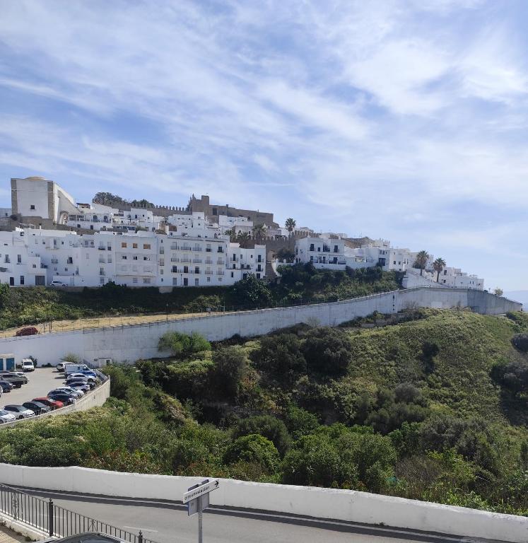 a white building on a hill next to a road at Casa Soledad in Vejer de la Frontera
