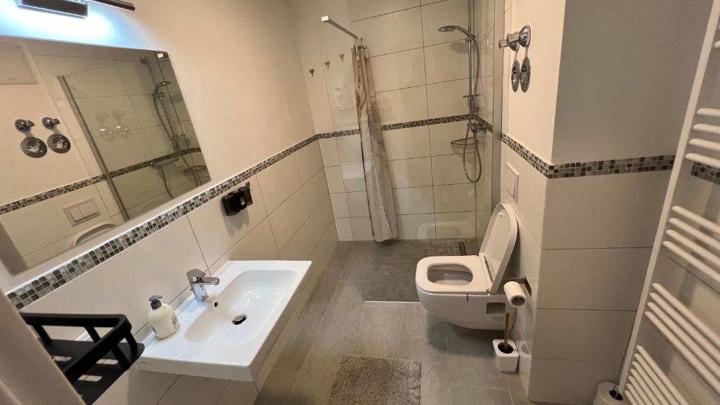 uma casa de banho com um lavatório, um WC e um espelho. em Reviv - Traumhaftes 3 Zimmer Apartment em Brühl