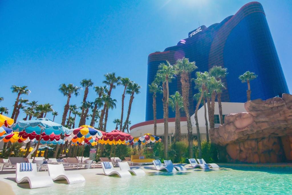 une piscine avec des chaises et des parasols en face d'un hôtel dans l'établissement Rio Hotel & Casino, à Las Vegas