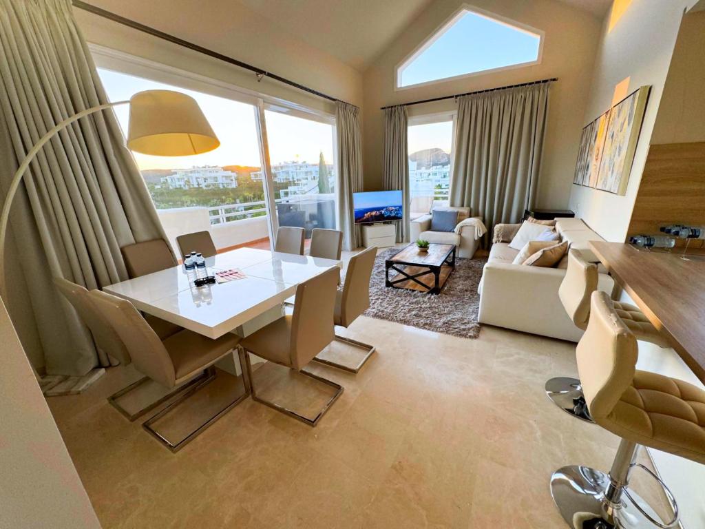 Luxury Penthouse Alcazaba Lagoon 622 EHHouse في إِستيبونا: غرفة معيشة مع طاولة وكراسي وغرفة معيشة