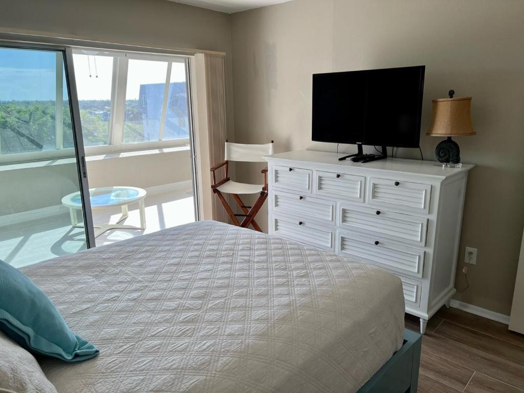 Dormitorio con cama y tocador con TV en 1200-602 Enjoy Relaxing Bayfront Bliss, en Sarasota
