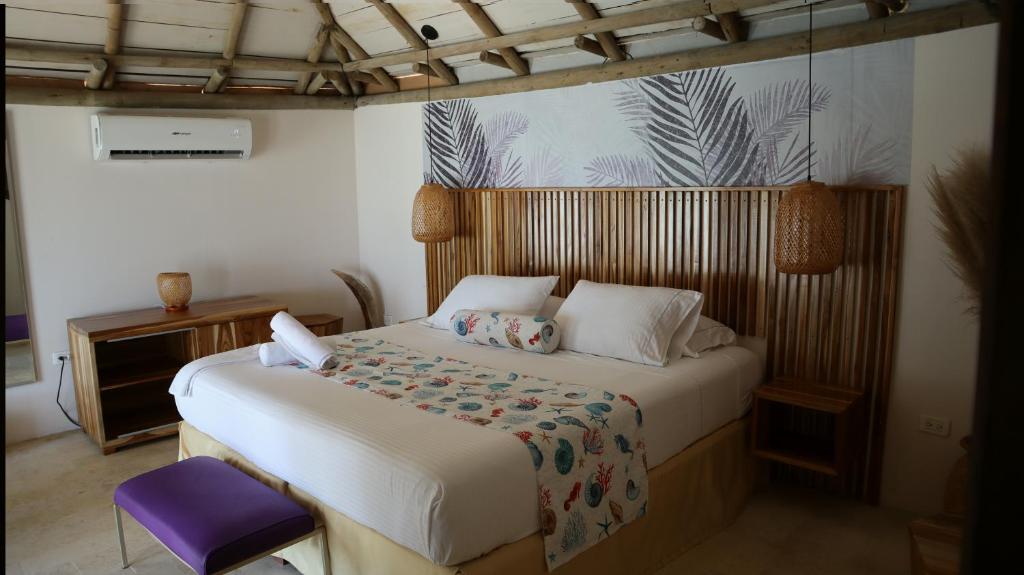 um quarto com uma cama e uma cadeira roxa em Hotel Rosario de Mar by Tequendama em Isla Grande