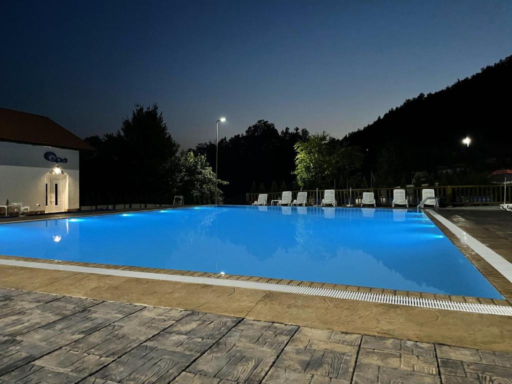 a large blue swimming pool at night at Etno Domacinstvo Mitrovic 