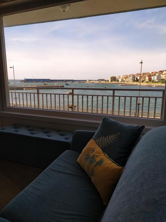 a couch in front of a window with a view of the beach at Vacacional muelle alto A Guarda in A Guarda