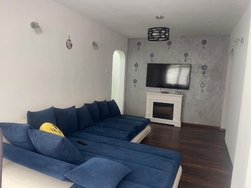 a living room with a blue couch and a tv at Carlitos apt in Râmnicu Vâlcea
