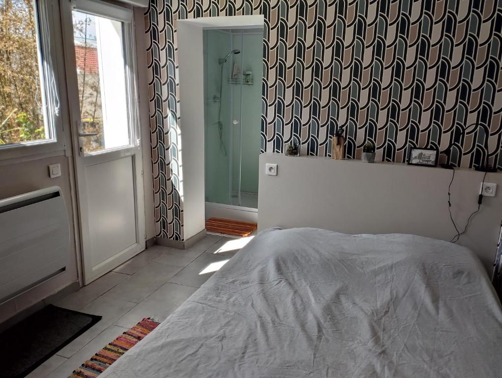 1 dormitorio con cama, ventana y ducha en chambre avec un accès indépendant et salle de bain et toilette privatifs, en Marquette-lès-Lille
