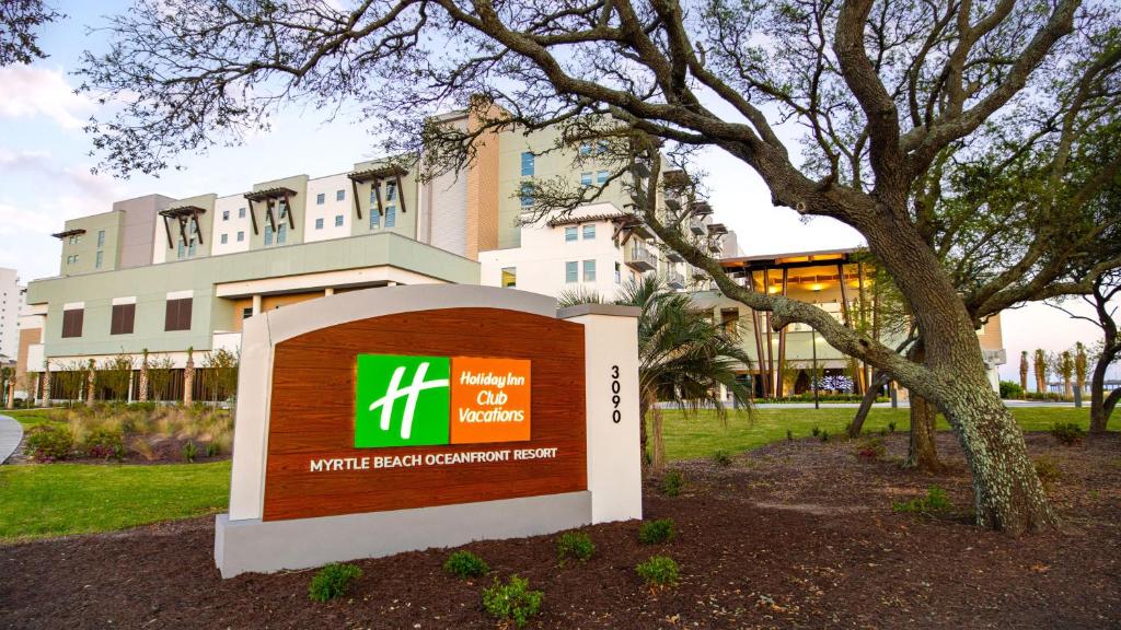 a sign in front of a building with a tree at Holiday Inn Club Vacations Myrtle Beach Oceanfront, an IHG Hotel in Myrtle Beach