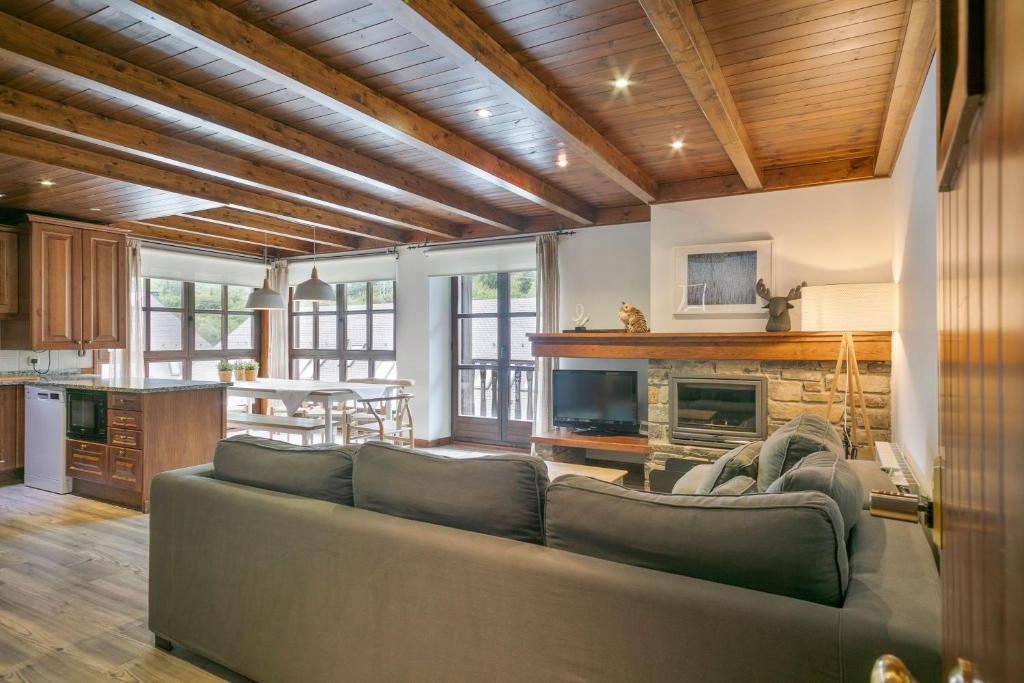 a living room with a couch and a fireplace at Luderna - Apartamento Val de Ruda B1 Morèdo in Baqueira-Beret