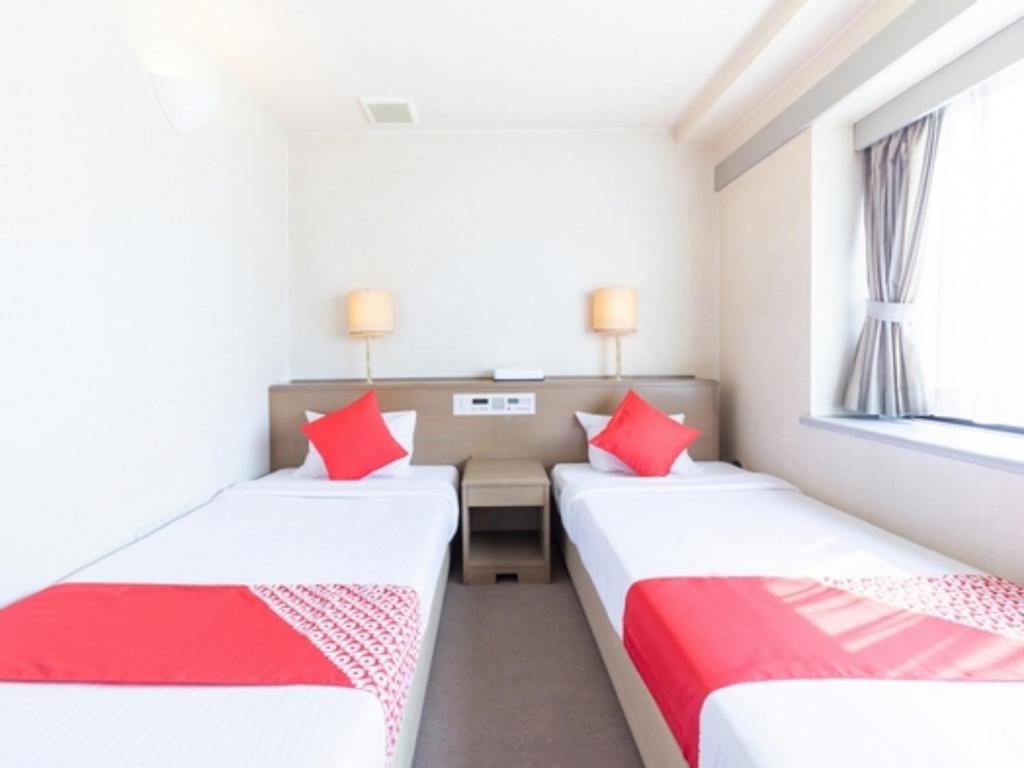 2 camas en una habitación con almohadas rojas en HOTEL DRAKE - Vacation STAY 61998v en Odawara