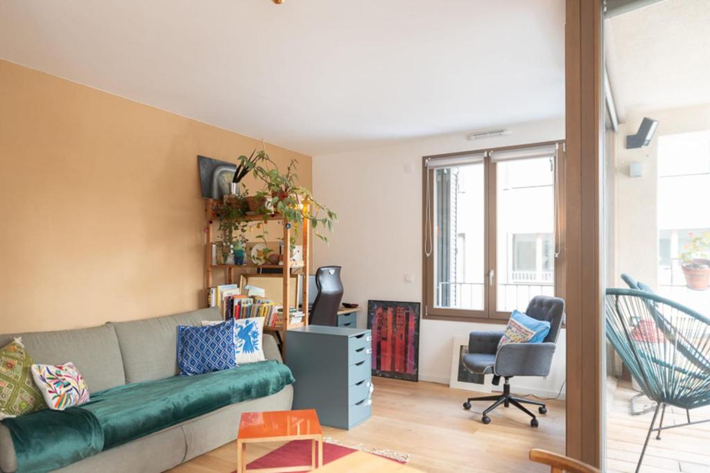 - un salon avec un canapé et une chaise dans l'établissement Cozy 55 m with terrace in Paris, à Paris