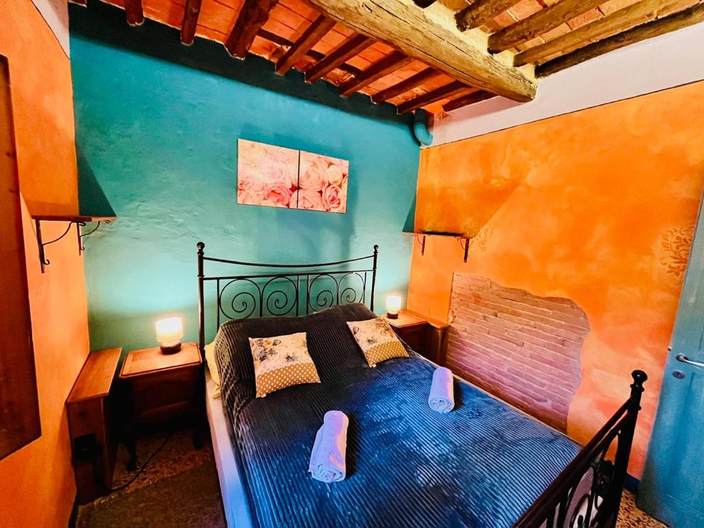 ein Schlafzimmer mit einem schwarzen Bett in einem Zimmer in der Unterkunft Turquoise Rose Apartment in Peccioli