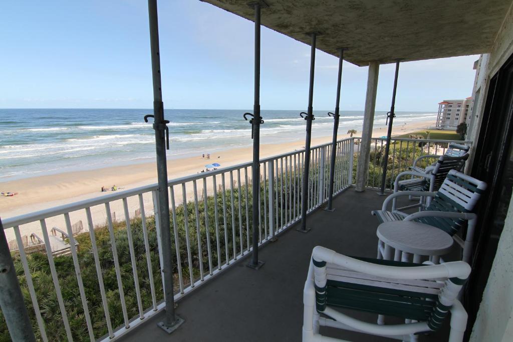 einen Balkon mit Stühlen und Strandblick in der Unterkunft Direct oceanfront with stunning corner views and pool access! in New Smyrna Beach