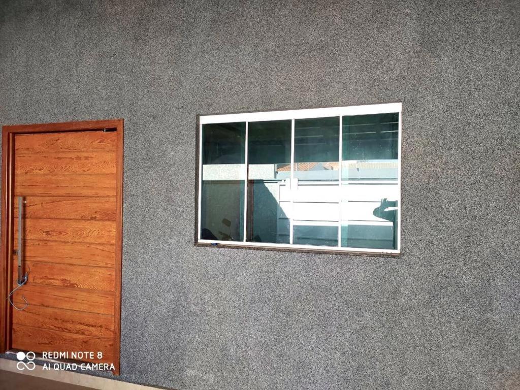 ein Fenster in einer Wand neben einer Tür in der Unterkunft Casa linda in Anápolis