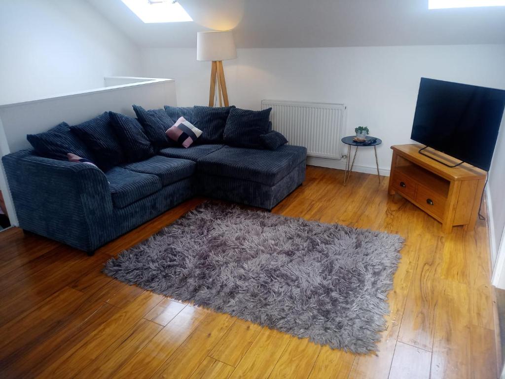 sala de estar con sofá azul y alfombra en Vic's Apartment, en Birmingham