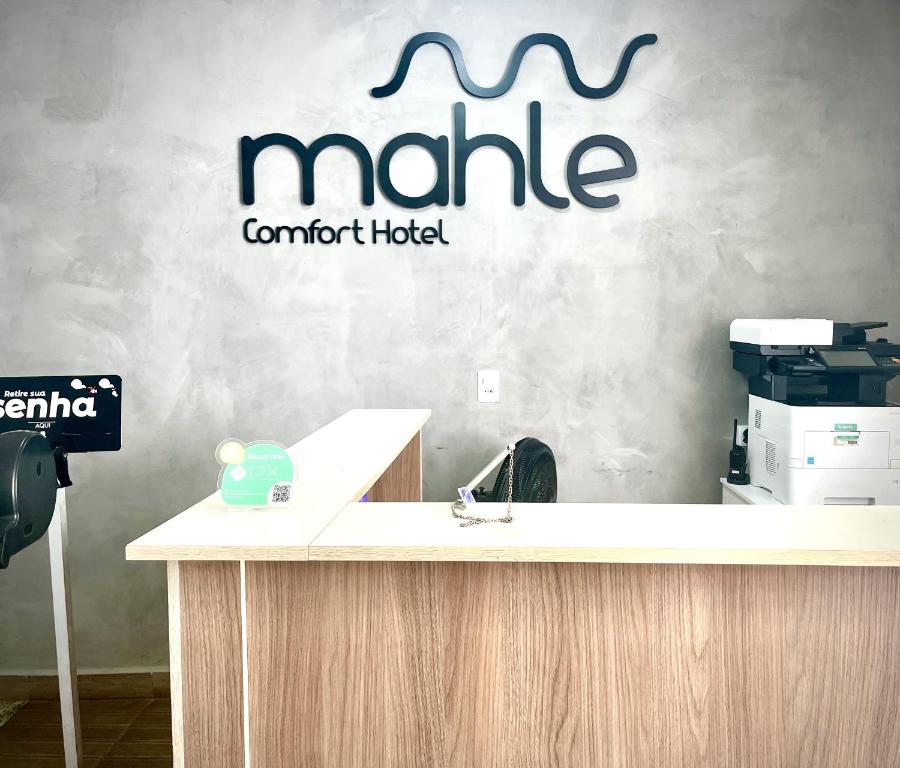 ein Büro mit einer Theke mit dem Schild an der Wand in der Unterkunft Mahle Comfort Hotel in Campina Grande do Sul