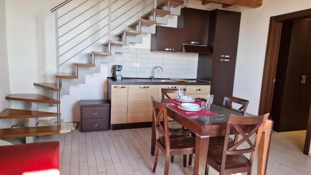 a kitchen with a dining room table and a staircase at Cala Dei Mori in Livorno