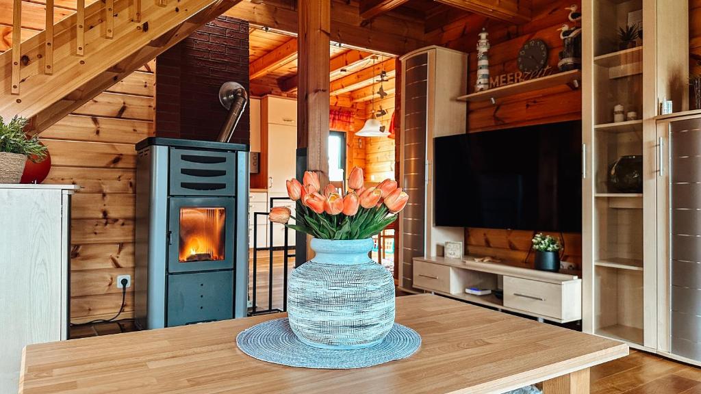 eine Blumenvase auf einem Tisch in einer Küche in der Unterkunft Blockhaus Rügen - Natur, Strand und Mee(h)r in Dranske