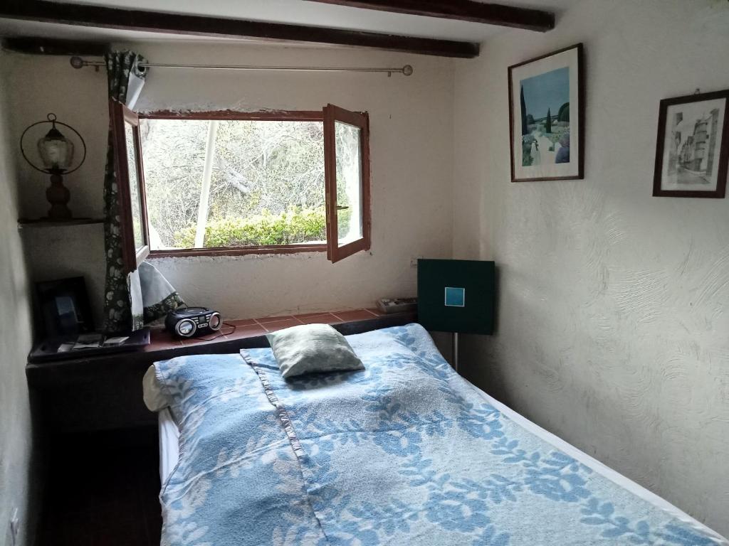 a bedroom with a bed and a window at AlpesAzur in Coursegoules