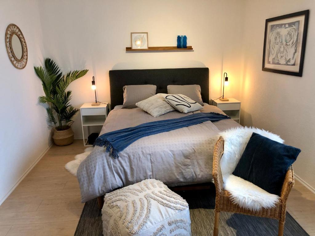 ein Schlafzimmer mit einem großen Bett und einem Stuhl in der Unterkunft Entzückendes Doppelzimmer in Steffisburg