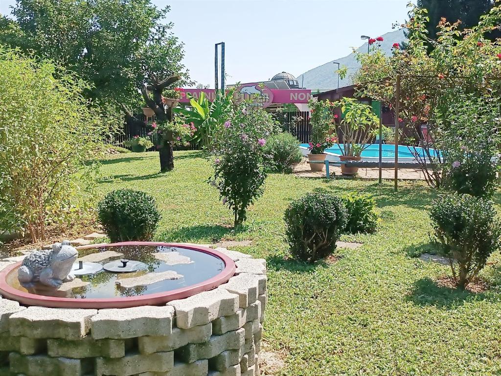 einen Garten mit einem kleinen Teich in einer Steinmauer in der Unterkunft Apartma Xanadu in Slovenske Konjice