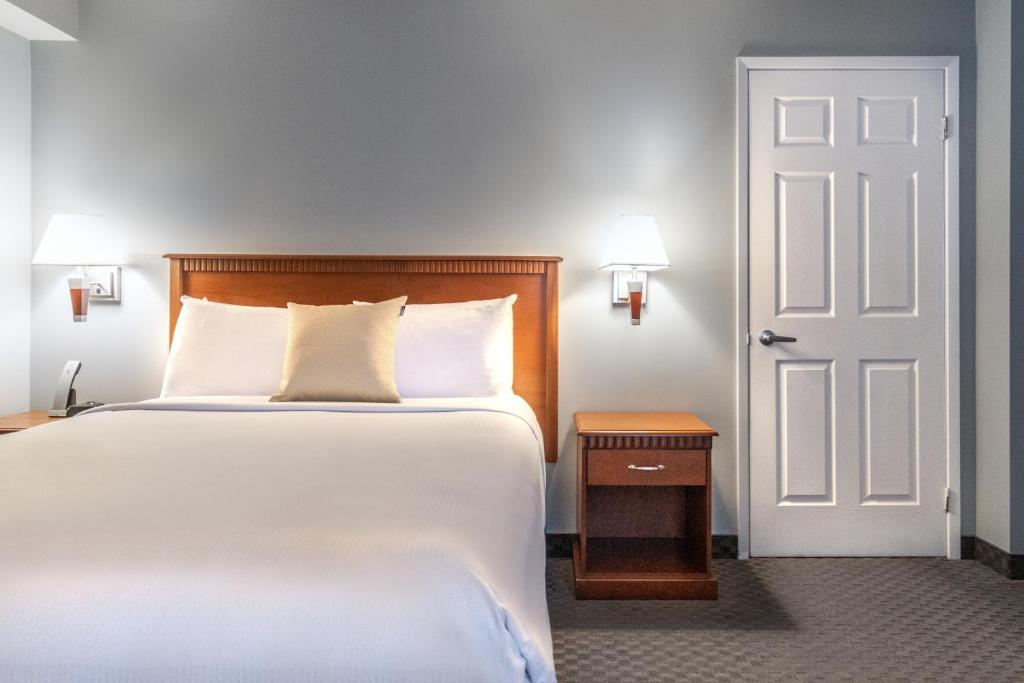 a bedroom with a large bed and a white door at Hôtel Saint-Laurent Montréal in Montreal