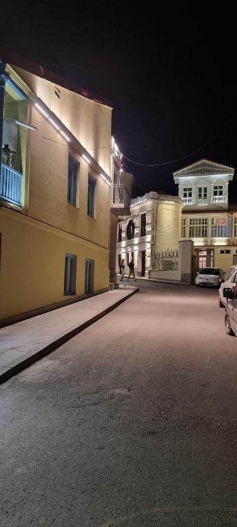 an empty street at night with two buildings at Harmonia in Tbilisi City