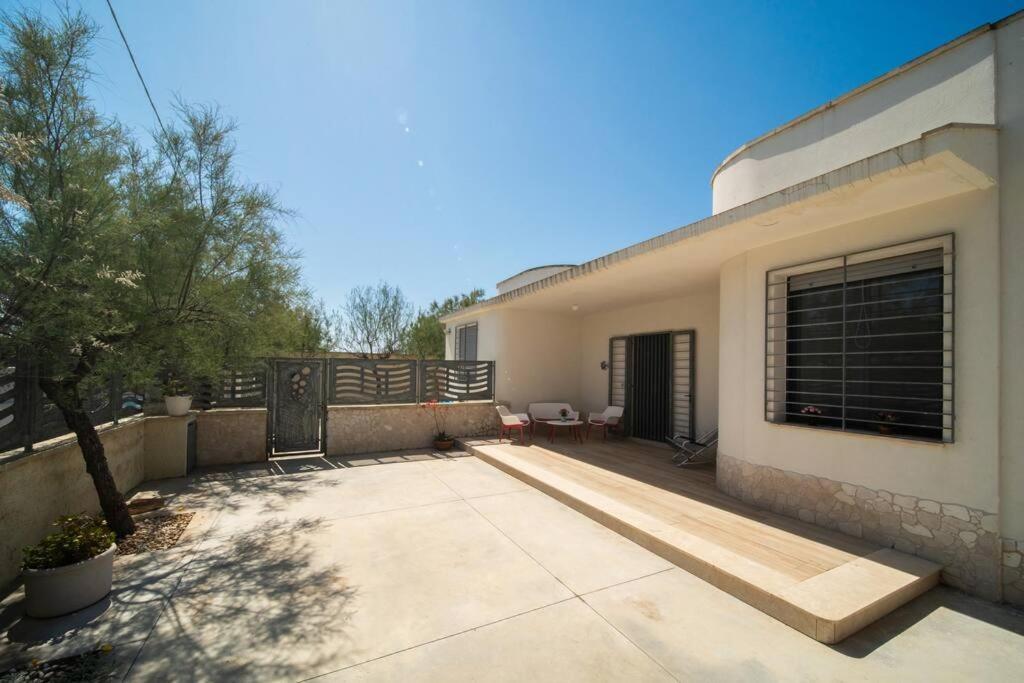ein Haus mit einer Terrasse und einem Zaun in der Unterkunft A un passo dal Mare - Villa Corallo Torre Borraco in Manduria