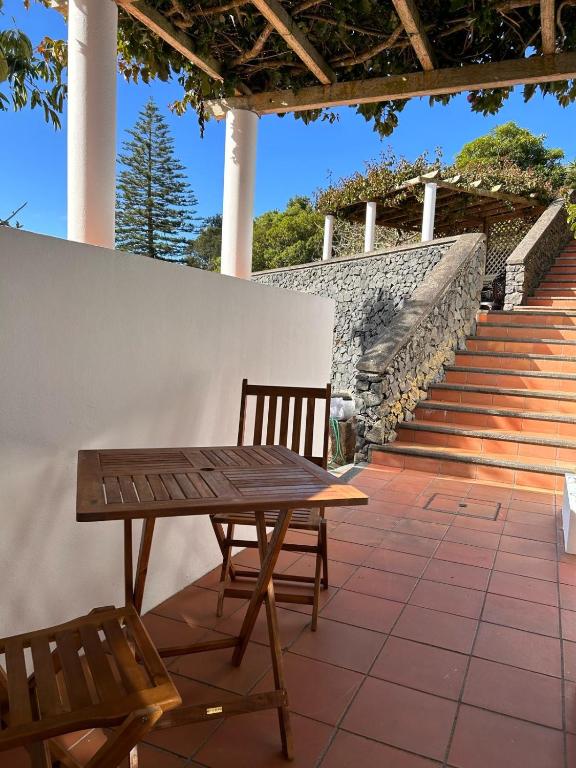 a wooden table and two chairs on a patio at Casa do Pombal in São Mateus