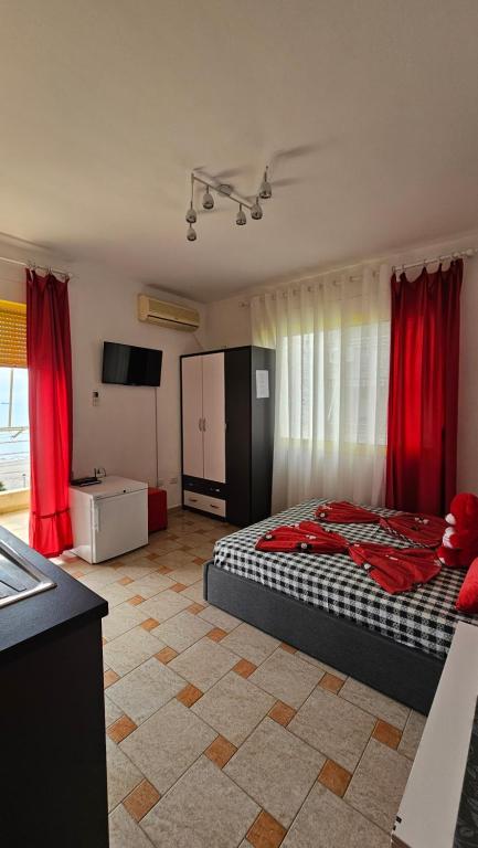 a bedroom with a bed and red curtains at Studio apartment Margo in Durrës