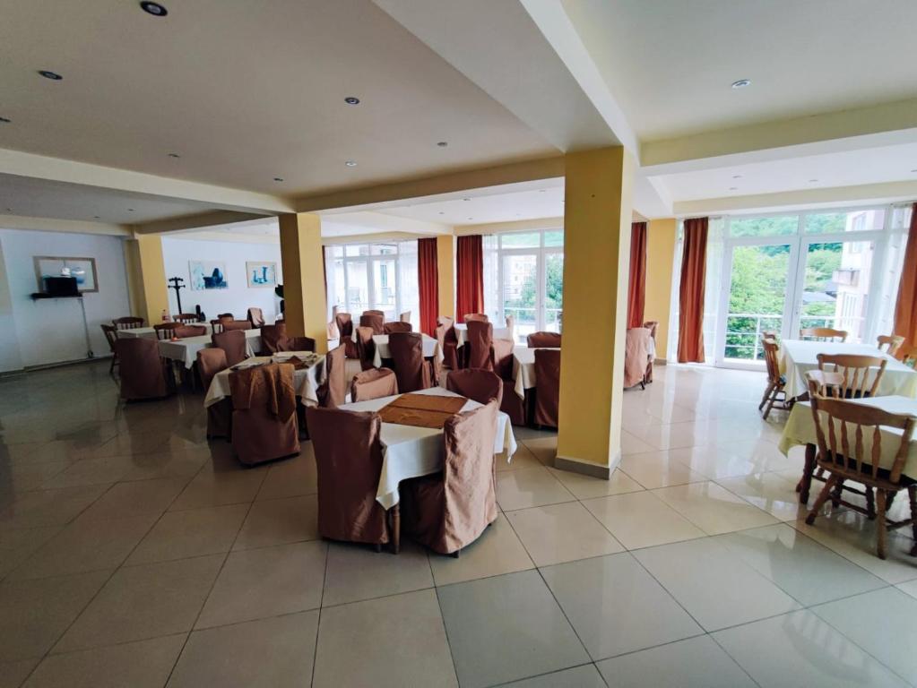um restaurante com mesas e cadeiras num quarto em Pensiunea Paradis Baile Herculane em Băile Herculane