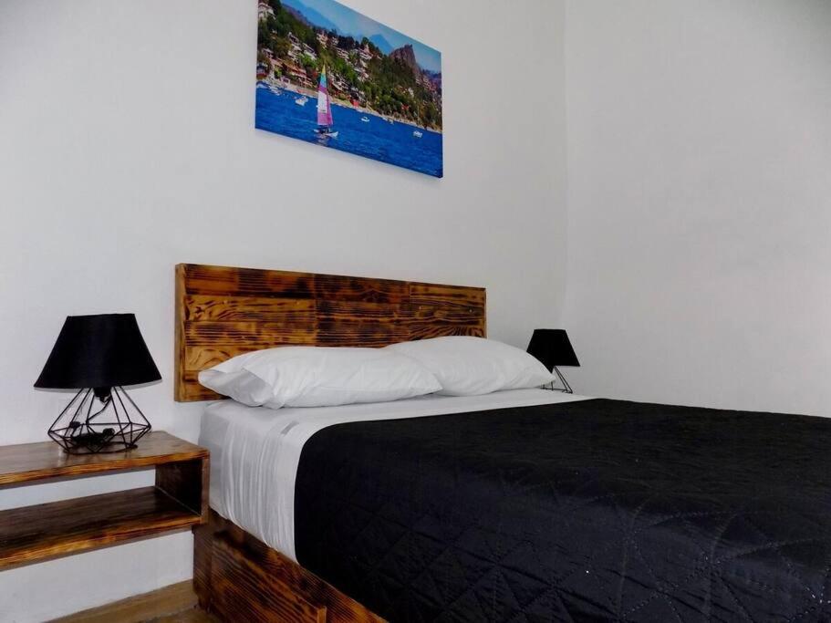 een slaapkamer met een bed en een foto aan de muur bij Quinta del Valle Suite Jr 3 2pax in Valle de Bravo