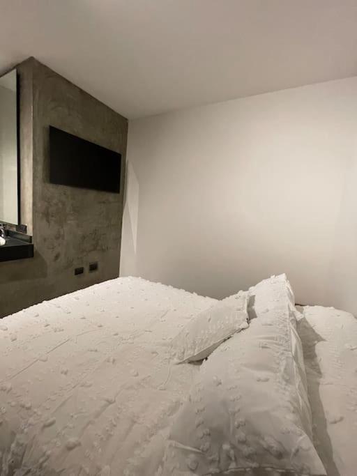 a white bed in a white room with a television at Casa Valentina Habitación 5 in Aguascalientes