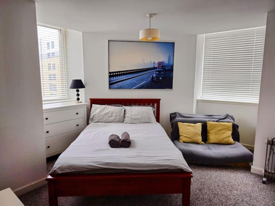 Un dormitorio con una cama con dos zapatos. en 2 Bedroom Modern stylish Apt in Glasgow City Centre en Glasgow