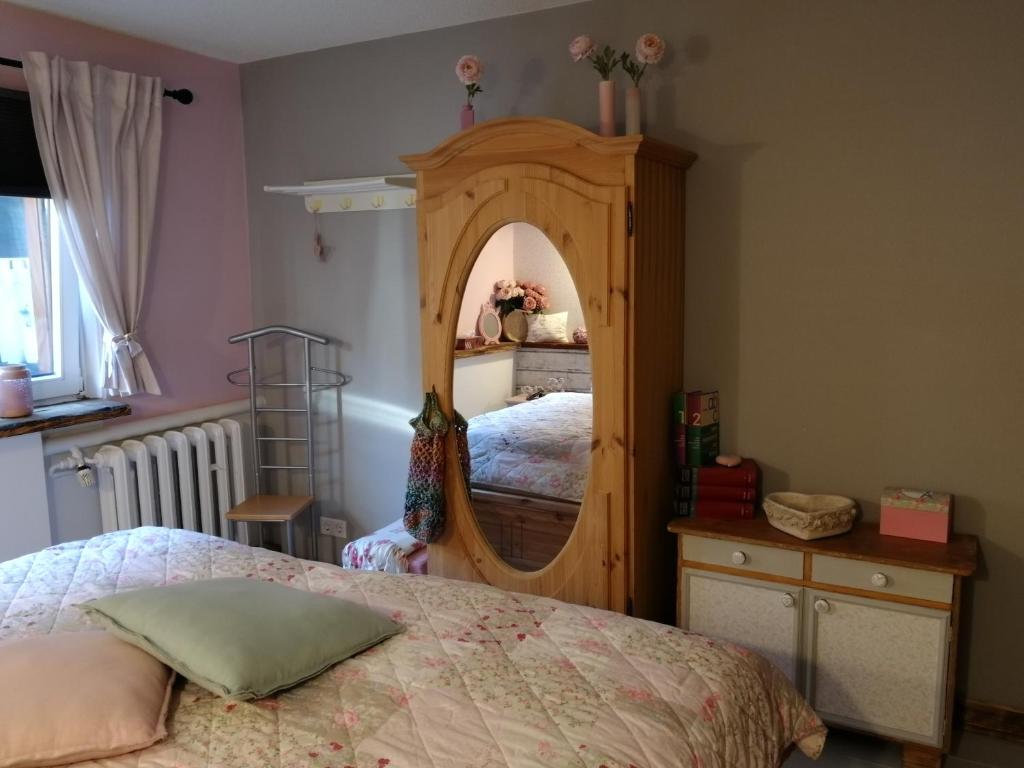 1 dormitorio con espejo grande y cama en Rosaly, en Stolberg im Harz