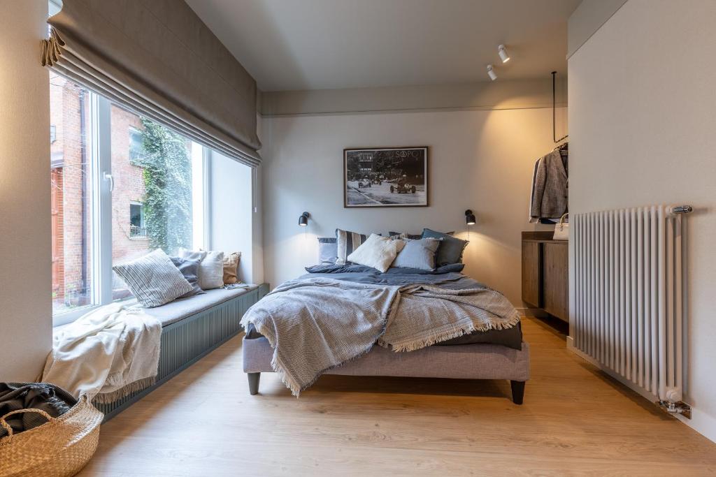a bedroom with a bed and a large window at Monciak Elegance - Plaża in Sopot