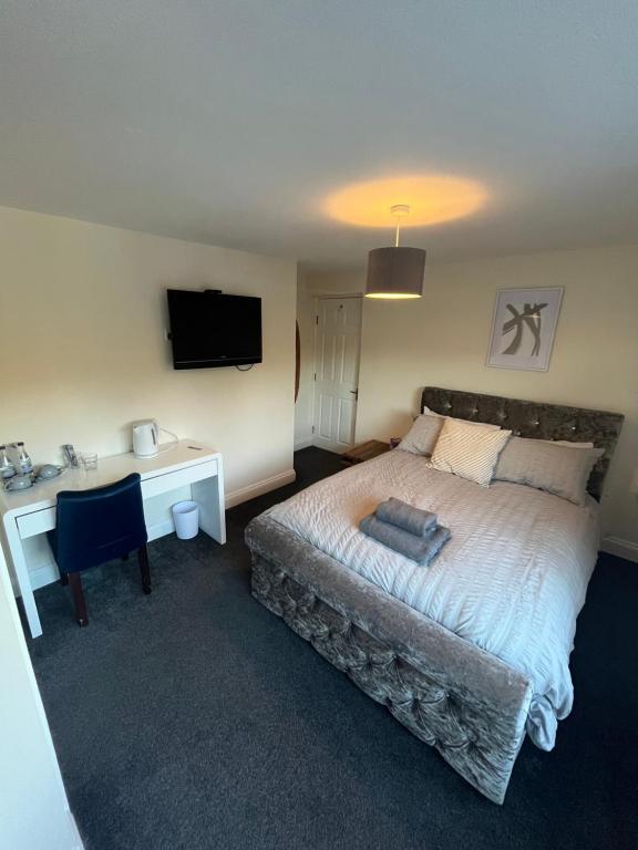 Dormitorio con cama, escritorio y TV en Half Moon Inn en Middlesbrough
