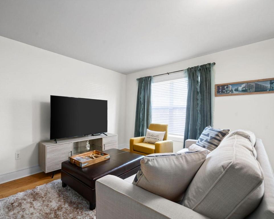 Una sala de estar con un sofá y un televisor de pantalla plana. en The Lofts of Downtown (540 N 2nd St, #210), en Clarksville