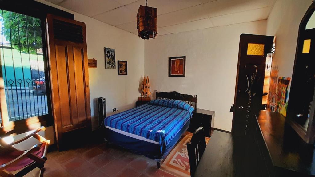 a bedroom with a bed with a blue blanket at Hotel Anáhuac in Juayúa