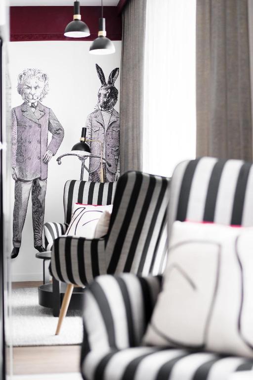 a living room with black and white chairs and a drawing of rabbits at Apartament Bajka in Grudziądz