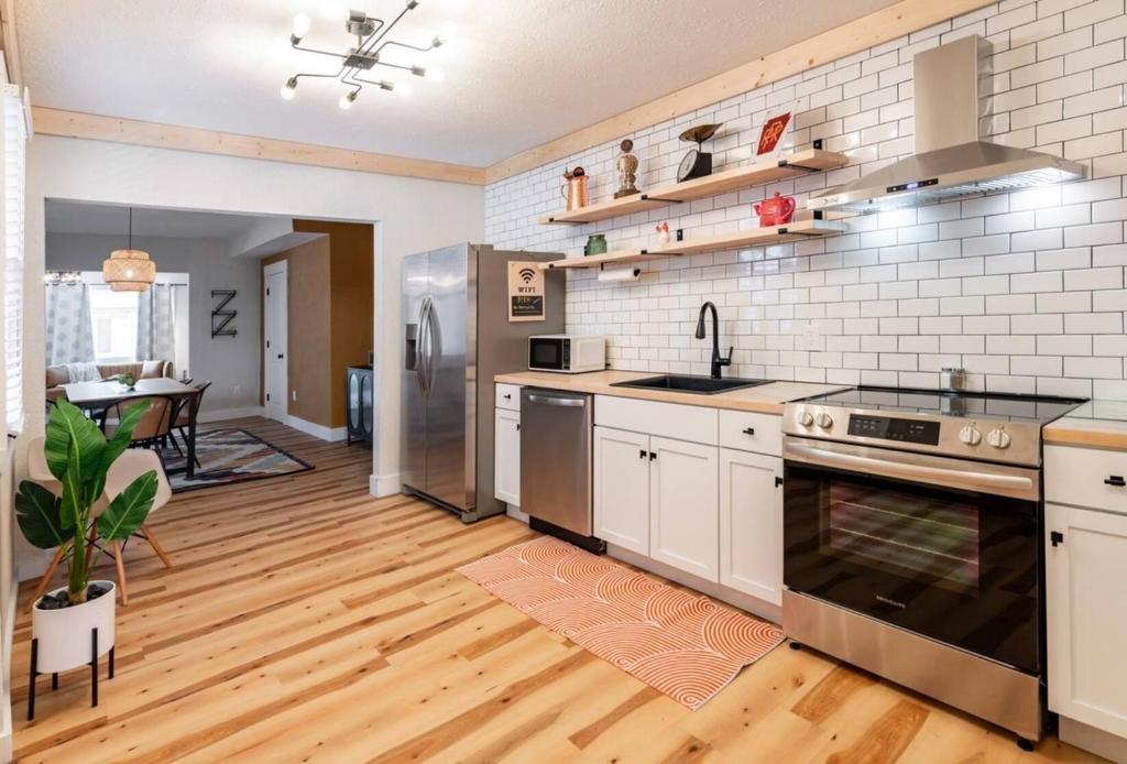 a kitchen with a sink and a stove top oven at Bridge City Row House in Pittsburgh