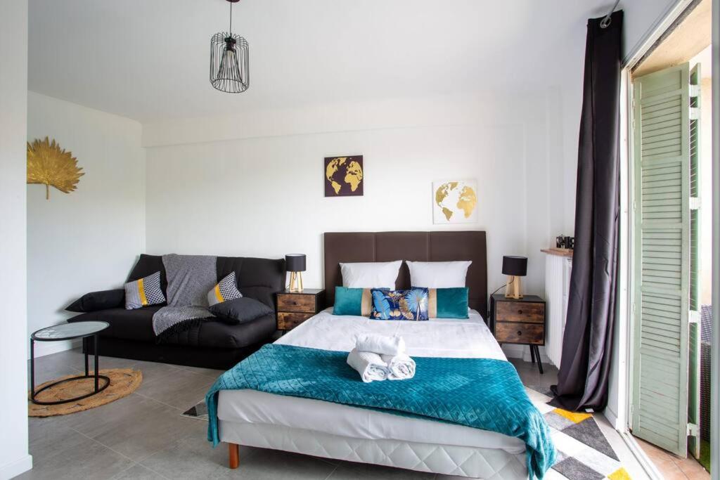 une chambre avec un lit et un canapé dans l'établissement 4 pièces 8 personnes proche aéroport,tramway, à Nice