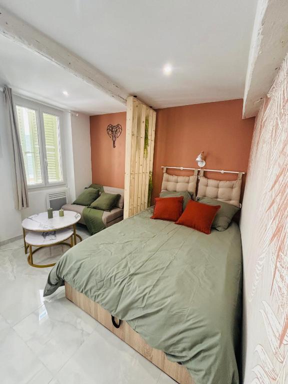 une chambre avec un grand lit et un salon dans l'établissement Le Charvet, Studio cosy en plein cœur de Hyères, à Hyères