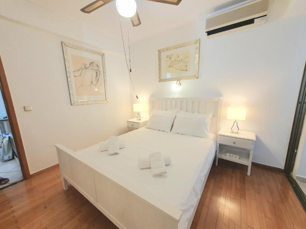 a bedroom with a large white bed with two lamps at Kavouri Seaside 85sqm Apartment 5' from the beach in Athens