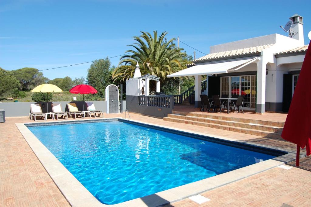 a swimming pool in front of a house at Villa Monte Alegrete with sea view in Santa Bárbara de Nexe