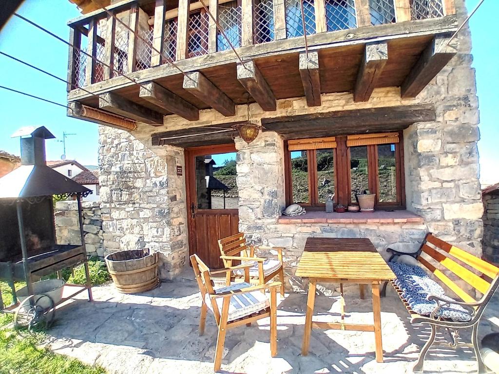 a patio with a table and chairs in front of a building at Casasdetrevijano Mirador de Mateo in Soto en Cameros