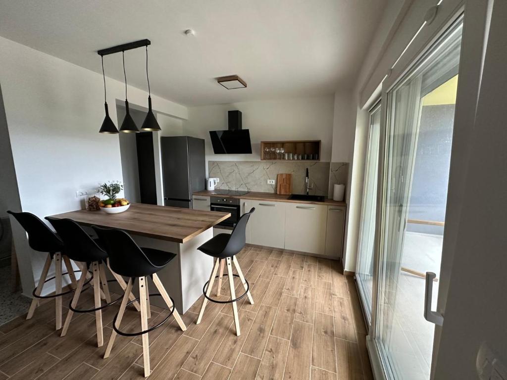 a kitchen with a wooden table and black chairs at Apartment Mila in Ugljan