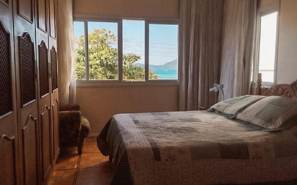1 dormitorio con cama y ventana grande en Fantástico apartamento Frente ao mar em Balneário Camboriú en Balneário Camboriú