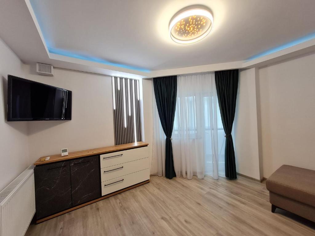ein Wohnzimmer mit einem Flachbild-TV an der Wand in der Unterkunft Romanescu One Apartament in Craiova