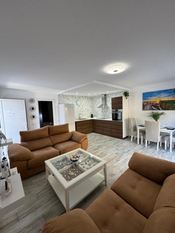 a living room with two couches and a table at Brisa del mar in Tarajalejo